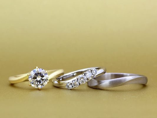 エンゲージリングとともにカーブを描くデザインに。女性用リングはプラチナ、男性用リングはホワイトゴールド。