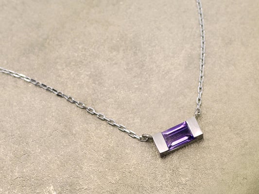 アメジストにホワイトゴールドを合わせた、ソリッドなデザインのペンダント。