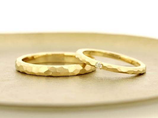 槌目模様をほどこしたイエローゴールドのリングを、サテン仕上げ（つや消し加工）に