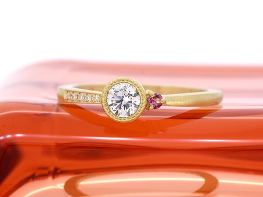 センターダイヤモンドの周りにミルグレインを。ピンクトルマリンがアクセントに