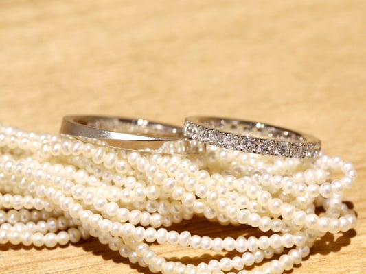 女性用リングは全周にダイヤモンドがあしらわれたフルエタニティ。男性用リングは、ななめのラインを境に上下の丸みを落として。