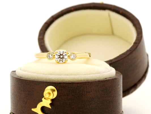 両サイドのメレダイヤモンドはミルグレインで囲みアンティークテイストに