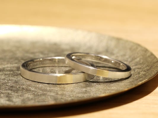 プラチナベースのシンプルなマリッジリングには、センターにイエローゴールドのアクセントを