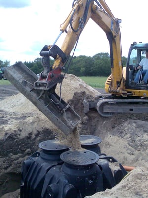 Die Baugrube wird mit Sand und Kieß gefüllt.