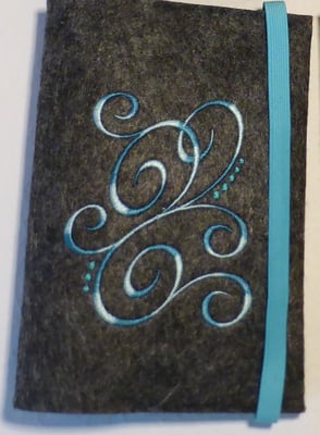 Stickmotiv Ranke mit Farbverlaufsgarn in türkis und Gummi in türkis auf Filz in dunkelgrau-meliert