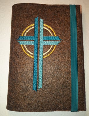 Stickmotiv Kreuz in petrol-türkis und Gummi in petrol auf Filz in braun-meliert 