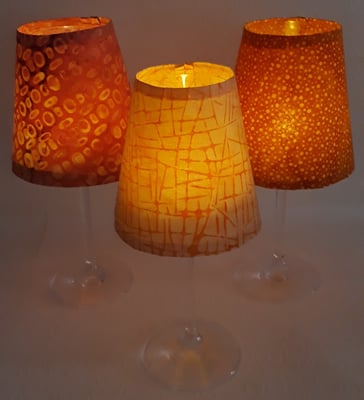 Diese Weinglas-Windlichter spenden sanftes Licht, Preis Schirm + Glas 7,50€. Aktuell sind keine fertigen vorrätig, Du kannst aber welche bestellen. Motive findest Du bei "Windlichter". 