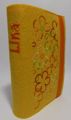 Stickmotiv Blumen in grün-orange auf gelbem Filz, Schriftart AR Cena