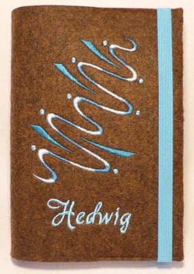 Stickmotiv Wasser mit türkisem Farbverlaufsgarn und Gummi in türkis auf braun-meliertem Filz mit Namen vorne, Schriftart akaDora