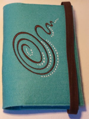 Stickmotiv Spirale in braun mit Gummi in braun auf Filz in türkis