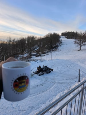 ein Warmgetränk und der Blick auf die Piste