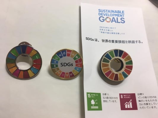 SDGsバッジ色々ー（左から）国連のお土産、BPW韓国のお土産、今回、BPW 日本がお土産に提供した木製バッジ。赤松良子元文相、クオータ制を推進する会代表のご挨拶。