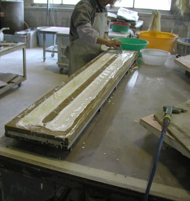 型に溶かした石膏を流し込み、補強の麻糸も入れる