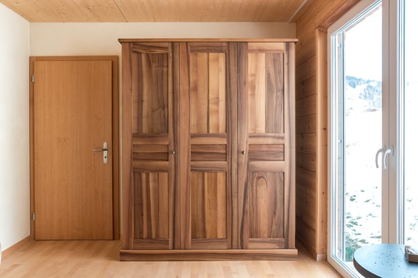 Dreitüriger Schrank aus Nussbaumholz mit gestemmten Türen und Füllungen.