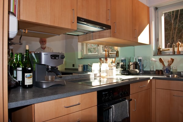 Küche aus Buche, Arbeitsfläche aus Granit, Küchenrückwand mit Spiegel.