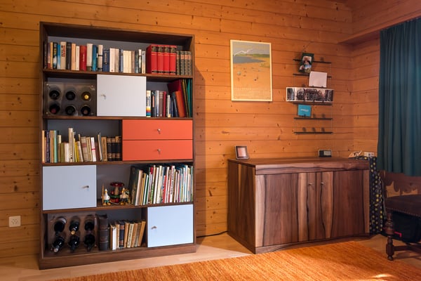 Bücherregal mit farbigen Türen und Schubladen. Sekretär aus Nussbaumholz.