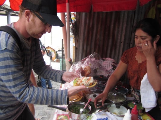 Hungriger beim Erwerb eines gutgehäuften Tostadas.