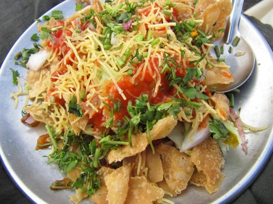 Straßensnack: frittierte Getreideflakes mit Zwiebeln, Kräutern mit einem süß-sauer-scharf Dressing.