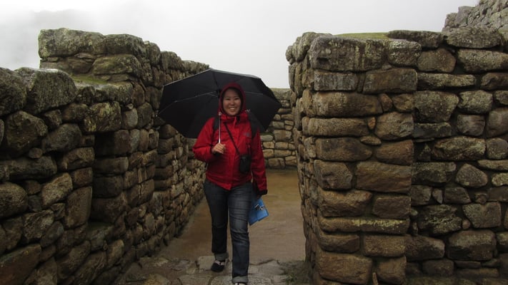 Mit Regenschirm bewaffnet in den Ruinen von Machu Picchu.