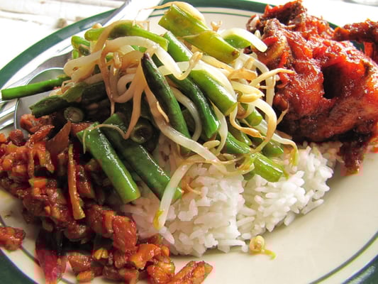 Mittagstisch. Viele Restaurants bieten über die Mittagszeit ein Buffet an. Links startet der Teller mit Tempe, dem Klassiker aus Sojabohnen, gefolgt von gebratenen Bohnen und Sojabohnensprossen und perfekt mit einem Chilli-Hühnchen abgerundet.