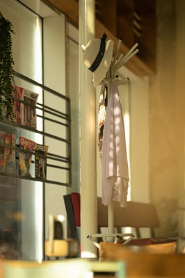 Sfeerbeeld van kapstok met kledingstukken in restaurant Bagel & Juice door Jordy Leenders van Axis Studio.