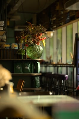 Sfeerbeeld van vaas met bloemen in restaurant Bagel & Juice door Jordy Leenders van Axis Studio.