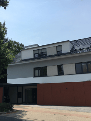 Immobilie frontale Ansicht weißes Gebäude mit Backsteinen und Garage