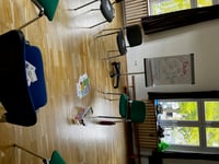 Seminarraum mit Stuhlkreis, Willkommens-Flipchart und ausgelegten Zitaten