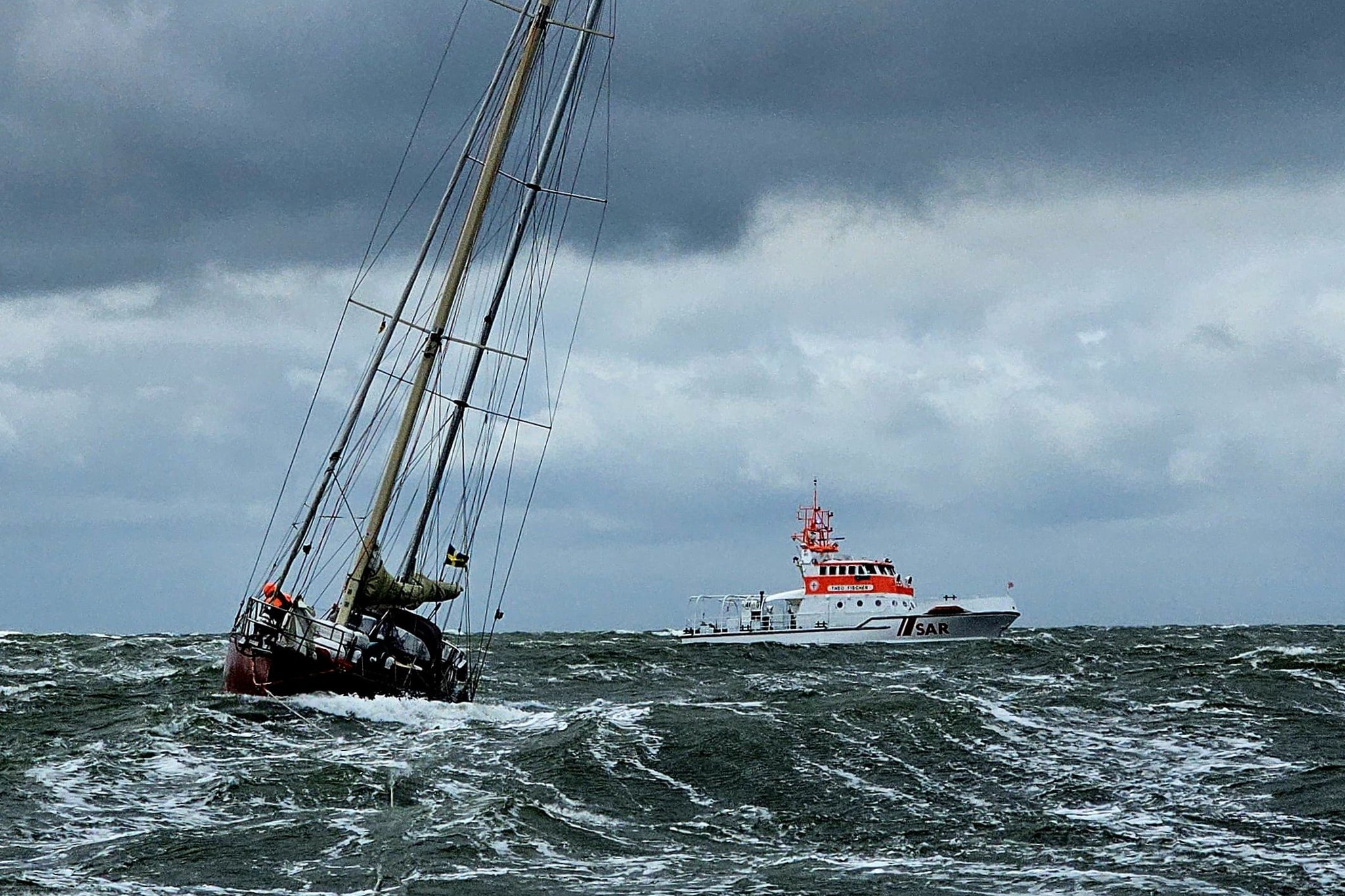Die havarierte Yacht im Schlepp des Tochterbootes kurz vor Borkum, im Hintergrund Seenotrettungskreuzer THEO FISCHER