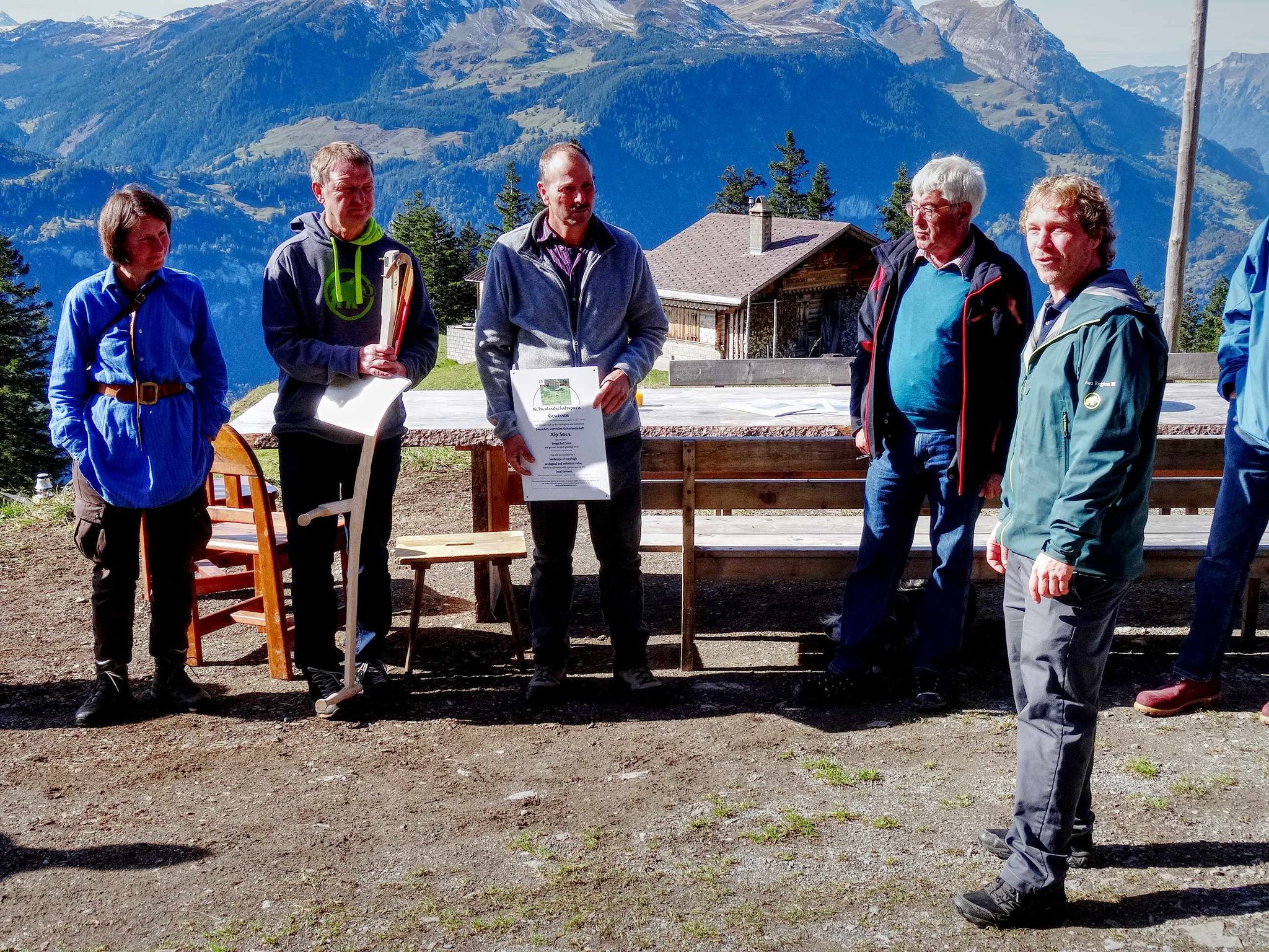 Thomas Durrer, Resort Director Lauterbrunnen Tourismus, übergibt die Sense Christian von Allmen