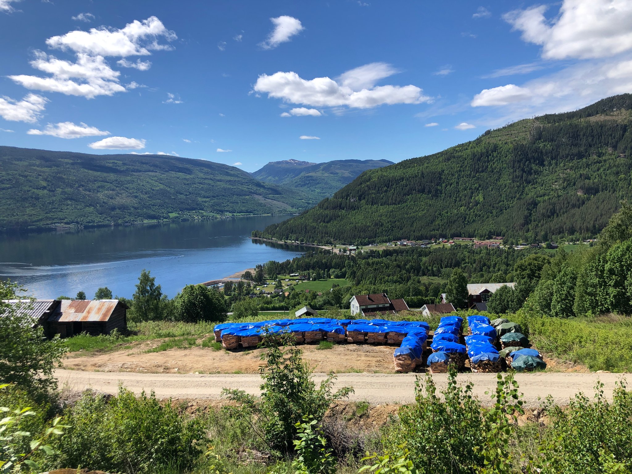 ved vannkanten se du Sjøtveit båtshavn og helt bakerst med den rø loven Sandviken Camping