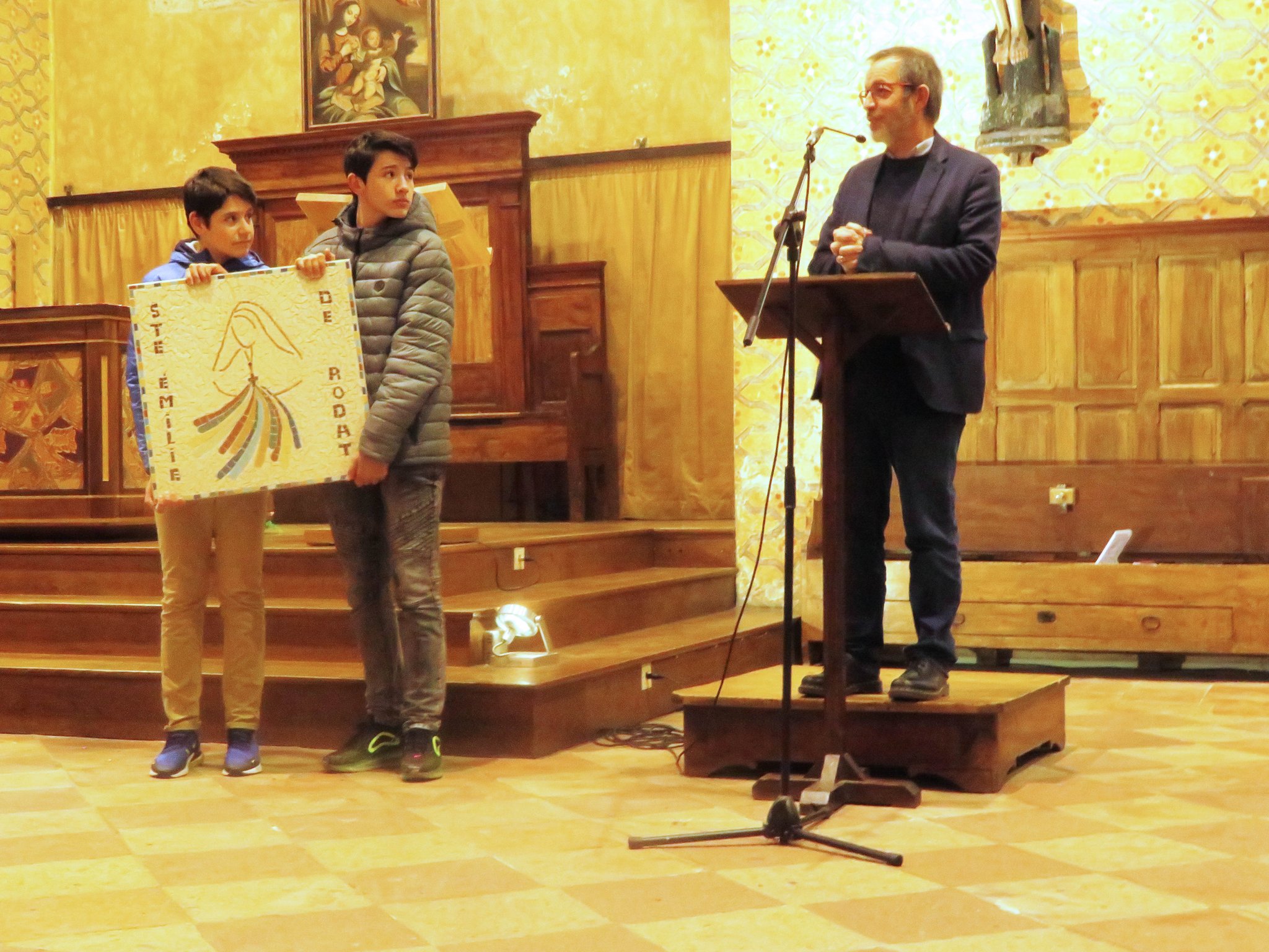 La dernière photo a été  prise à l'abbatiale lorsque le directeur remerciait les élèves présentant l'ouvrage terminé, ils allaient décider où le placer dans l'école  du groupe scolaire de la Sainte Famille Emilie de Rodât 
