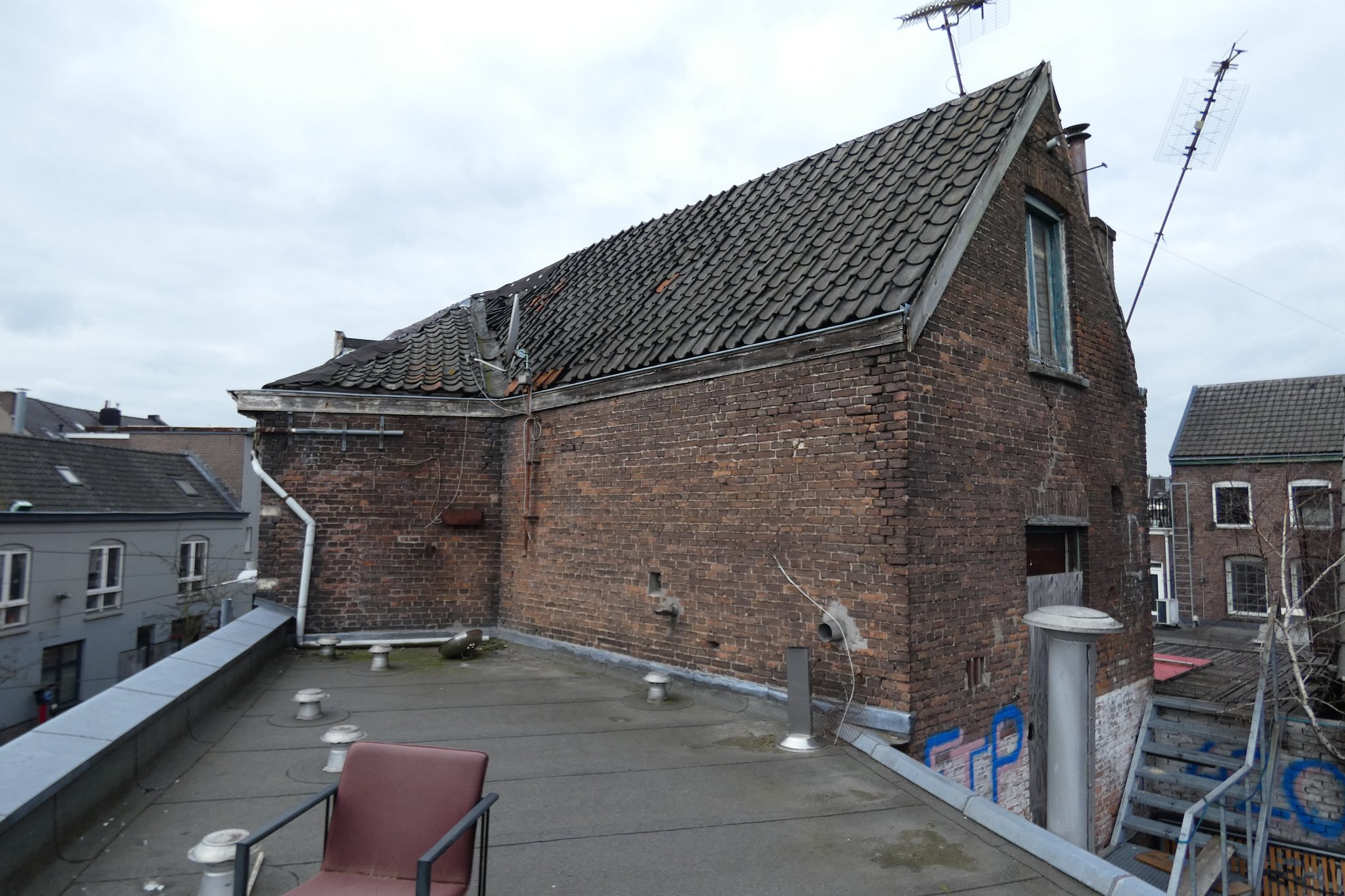 Vanaf het plat dak van de buurpanden is de opvallende knik in Tweede Walstraat 100-102 goed zichtbaar. 