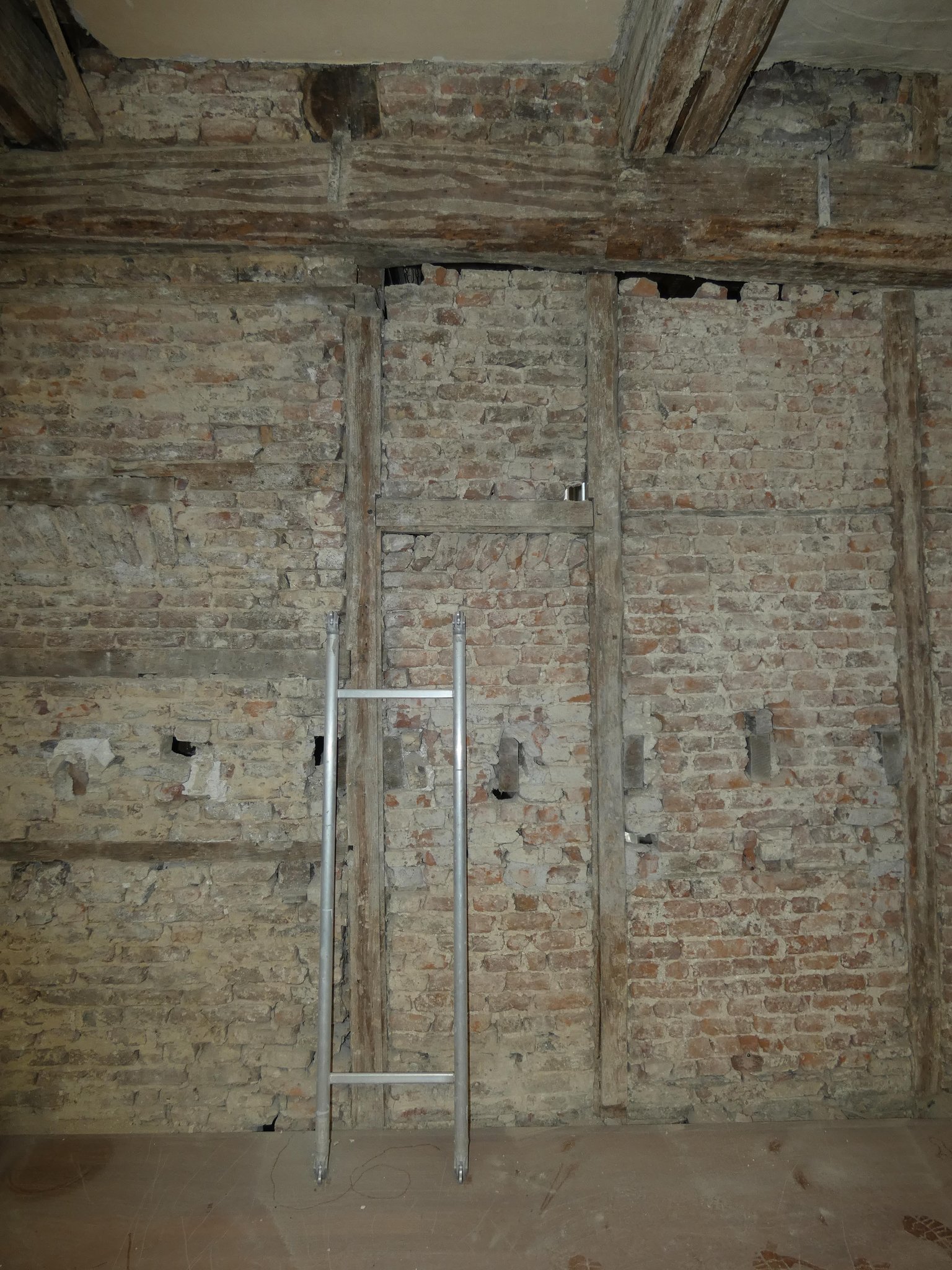 Zuidelijke muur in het westelijke vertrek op de verdieping: voormalige doorgang (deursponningen) en de balkkoppen van de drielaags opzet uit 1905.