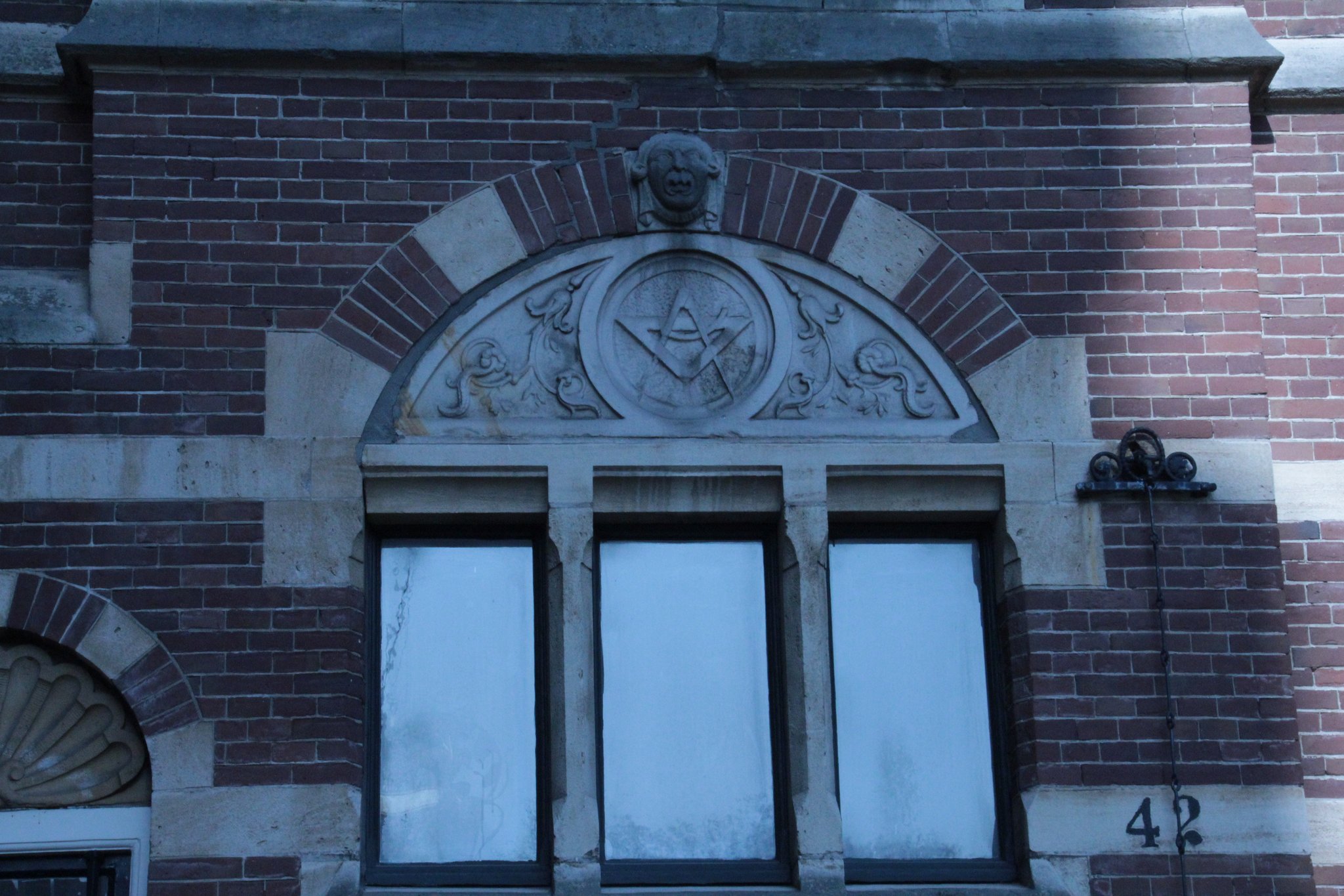 Vensterparrij met vrijmetselaarsteken in het boogveld. 