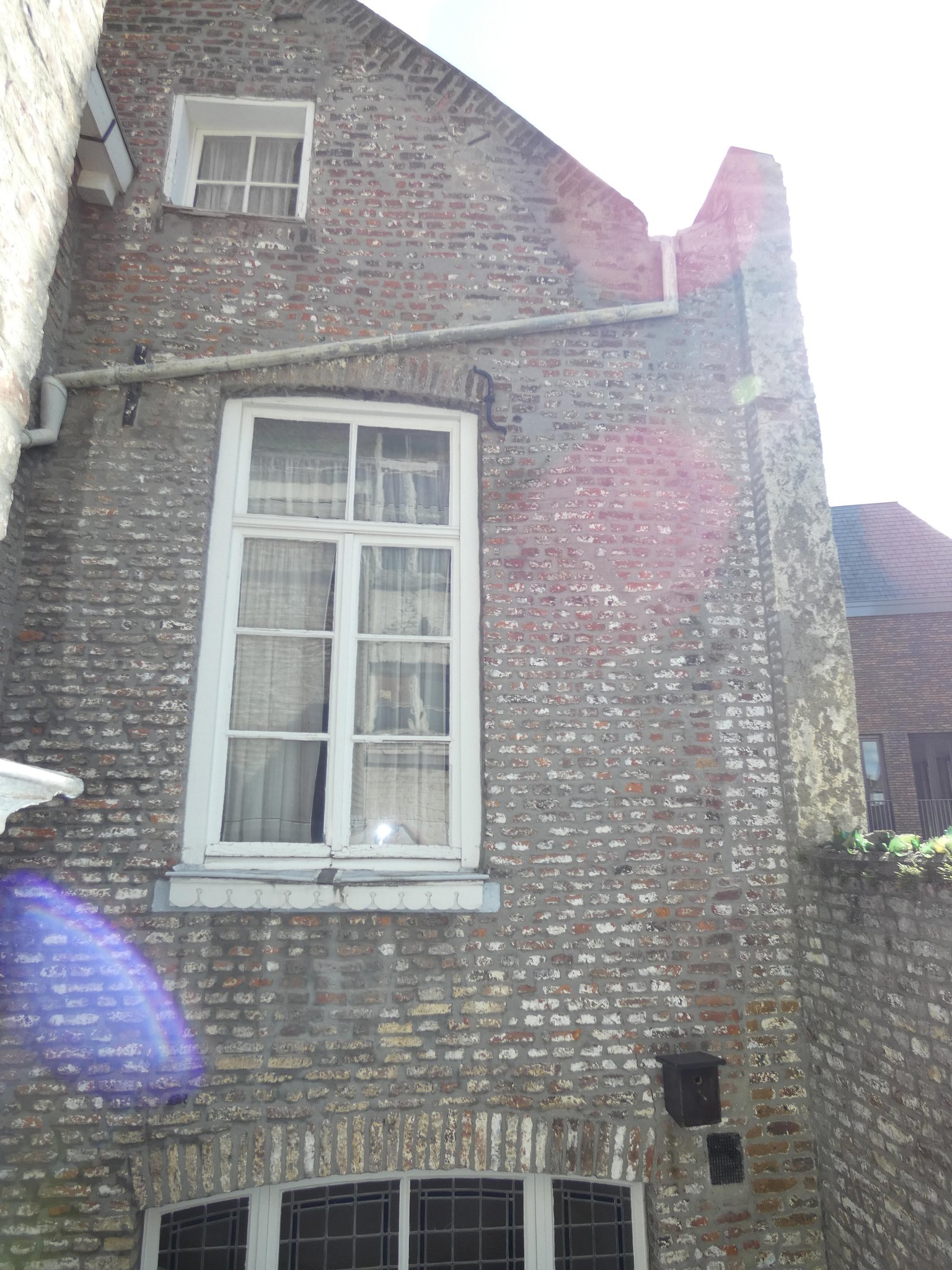 Westgevel van het oostelijke volume. Rechts naast het venster is de bouwnaad van de dichtgezette spouw zichtbaar. 