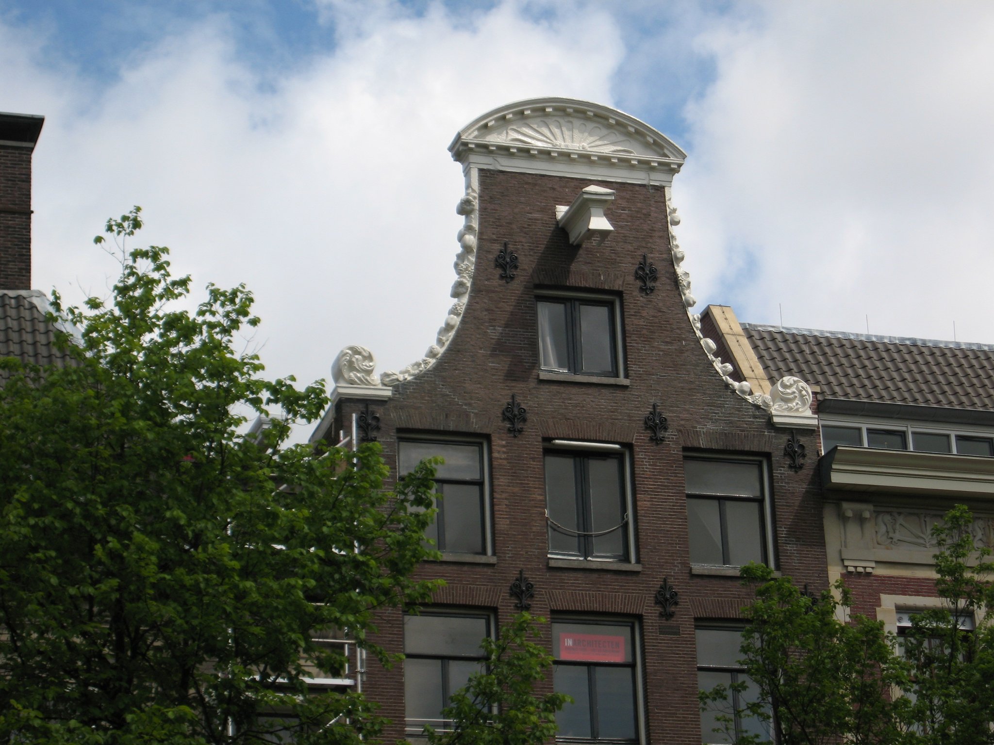 Detail van de klokgevel met festoenen, fronton en hijsbalk.