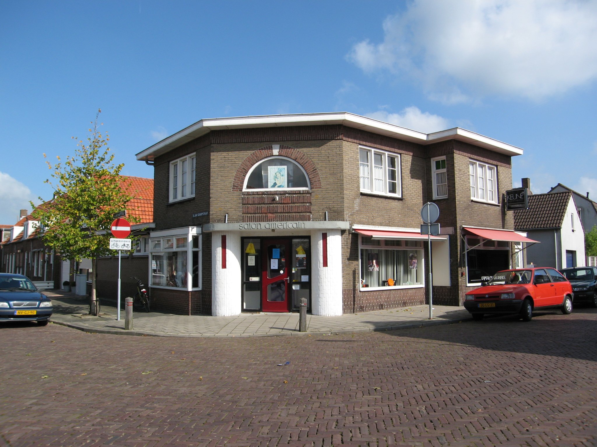 Salon Americain aan de Prins Hendrikstraat. Karakteristiek hoekpand uit de jaren dertig. 