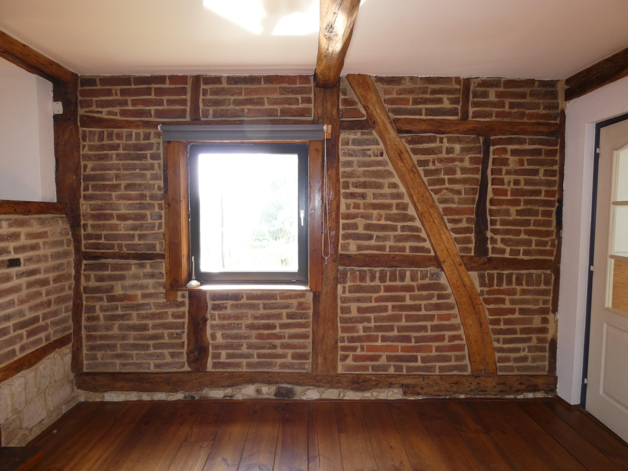 Relicten van de vakwerkconstructie van de voorgevel. Niet vroeg- maar laat-negentiende-eeuws en aangepast vanwege venster. 