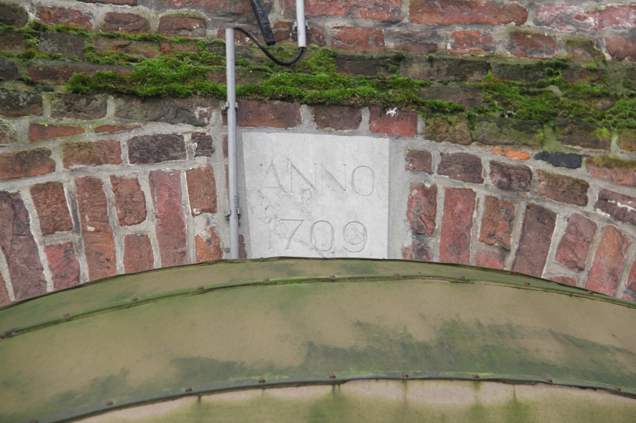 Gevelsteen met jaartal 1709, boven de poortopening aan de Berlostraat