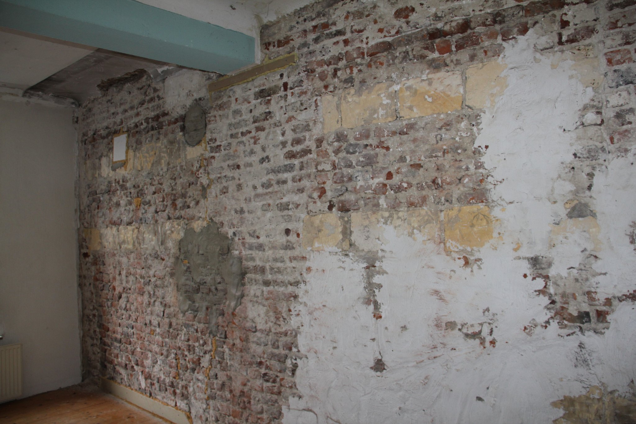 Bouwsporen onder de stuclaag in het achterhuis (tweede verdieping). 