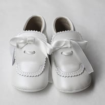 Chaussons bapteme bébé montant en cuir souple blanc cassé avec noeud en satin. Chaussons cérémonie bébé Fil de Légende. Magasin vêtements baptême cérémonie bébé Paris, Neuilly-sur-Seine.