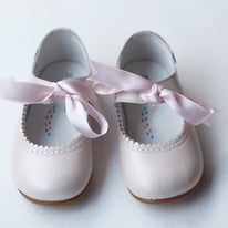 Chaussures ballerines de cérémonie pour petites filles en cuir rose et ruban de satin rose. Magasin vêtements cérémonie enfants Paris, Neuilly-sur-Seine. Expéditions en France et à l'international.