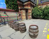 Five historic wooden beer barrels at the entrance to Aldaris brewery in Riga