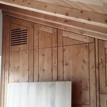 ein Schrank aus Zirbenholz im Schlafzimmer mit Schlitzen für die Klimaanlage
