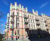 Facade of of pink, neo-Gothic, five-story Hotel Monika in Riga
