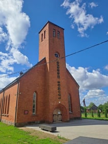 Brown brick historic Lutheran church housing the Museum of Happiness in Indra, Latvia.