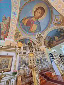 Interior of Russian Orthodox Cathedral in Ludza, Latvia, with iconostasis and a large ceiling mural depicting Jesus