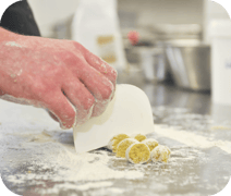alt="Küchenteam von Naturkost Strohmaier bei der Essenszubereitung"