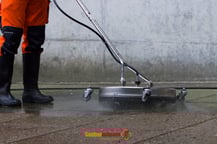 Mitarbeiter mit einem Hochdruckreiniger auf Steinen